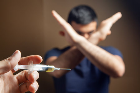 the man refuses to accept the syringe. vaccination concept. addictionの写真素材
