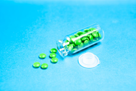 pills scattered from a flask on a blue table