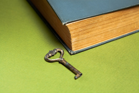 old key and book on a green backgroundの写真素材