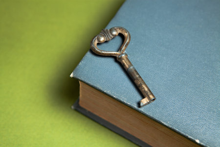 old key and book on a green backgroundの写真素材