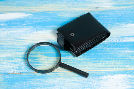 magnifier and wallet on wooden tableの写真素材