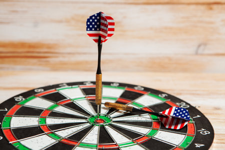 darts in the center of the target on a wooden background