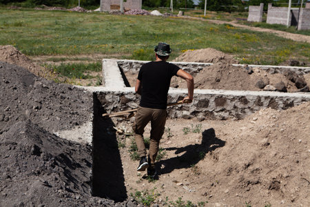 a man works on the construction of a one-story houseの写真素材