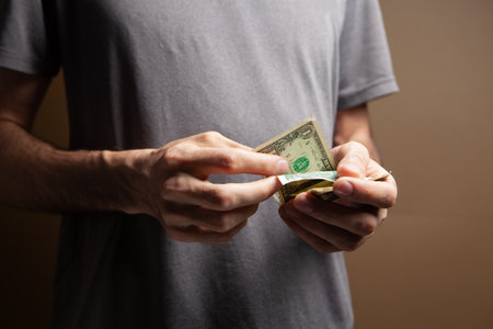 Man counting money on brown backgroundの写真素材
