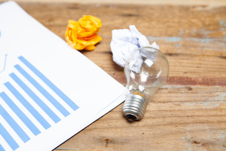 light bulb, crumpled papers and graph.