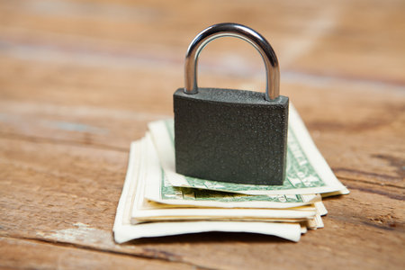 lock on dollar bills on a wooden tableの写真素材