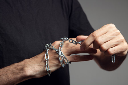a man winds a chain around his handの写真素材