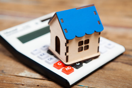 house and calculator on a wooden table. calculating house costsの写真素材