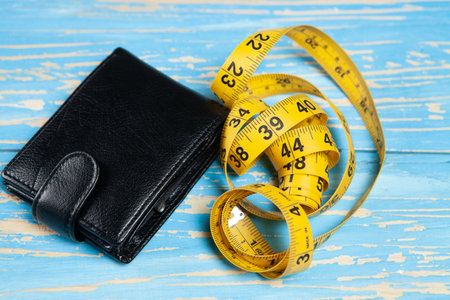 measuring tape and wallet on a yellow backgroundの写真素材