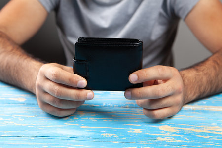a man holding a wallet at the tableの写真素材