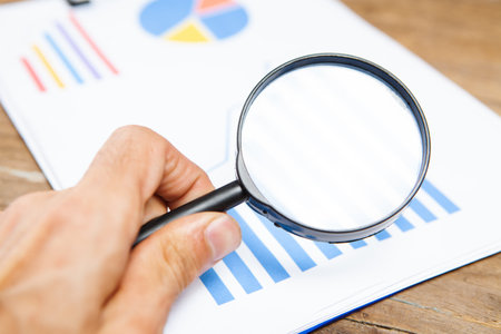 magnifying glass looks at statisticsの写真素材