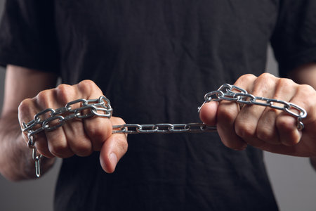 a man holding a chain in his fistsの写真素材