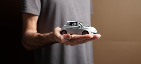 a man holding a toy car in his handsの写真素材