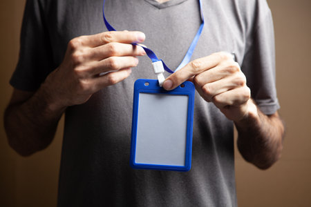 man holding id tag on brown backgroundの写真素材