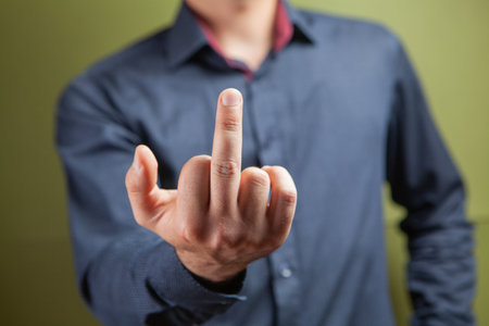 Man showing middle finger on green backgroundの写真素材