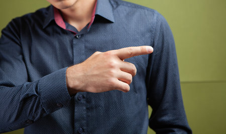 man points to the side on a green backgroundの写真素材