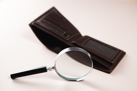 magnifier and empty wallet on the tableの写真素材