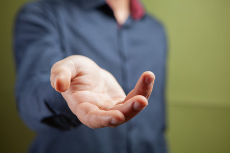 man shows open palm on green backgroundの写真素材