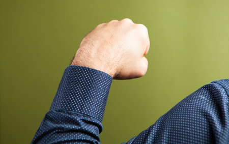 Man holding a fist on a green background