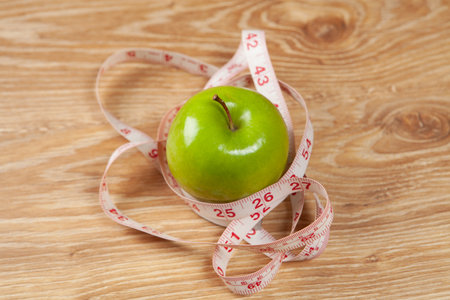 measuring tape and apples on the tableの写真素材