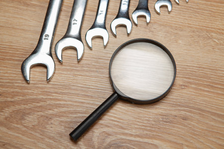 magnifier and wrenches on the table. concept search technical support