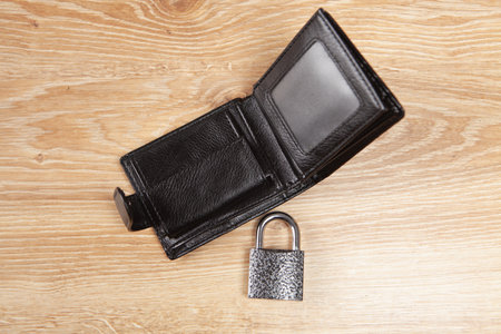 padlock and black wallet on a wooden table. money security conceptの写真素材