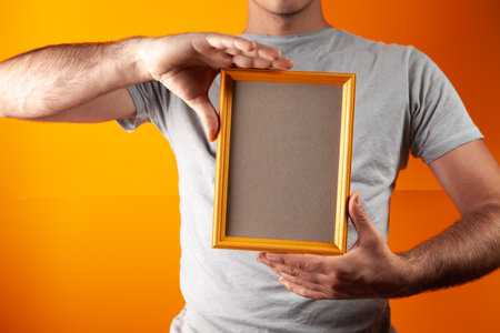 man holding house keys on orange backgroundの写真素材