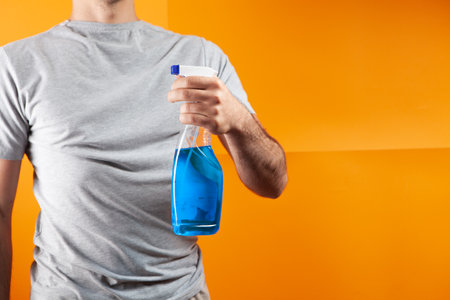man holding detergent on orange backgroundの写真素材