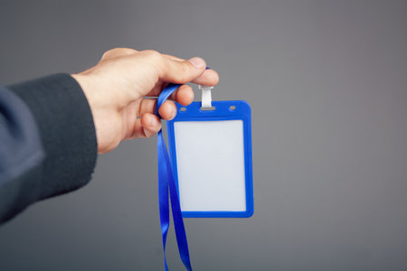 hand holding id tag on gray backgroundの写真素材