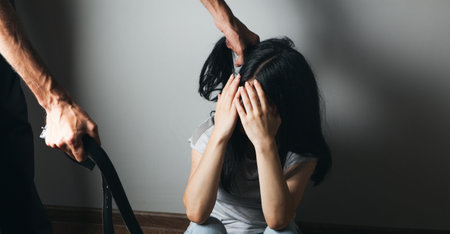 husband beats his wife with a belt. domestic violenceの写真素材