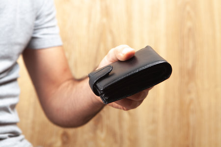 a man gives a wallet on a wooden background