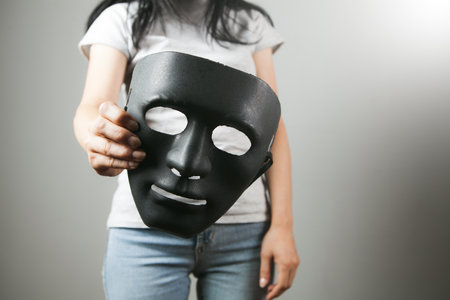 woman holding black anonymous maskの写真素材