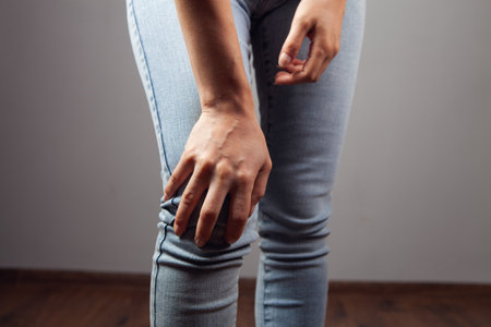 woman has knee pain on gray backgroundの写真素材