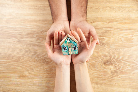 couple holding a house in their hands. view from aboveの写真素材