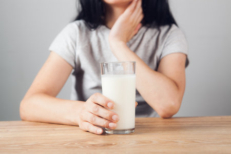 girl at the table holds a glass of milkの写真素材