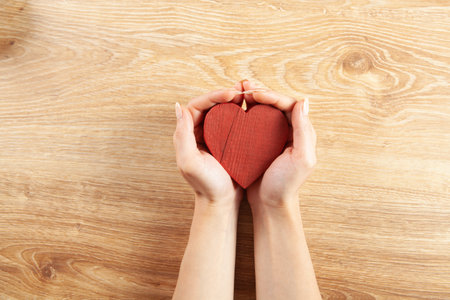 woman holding a wooden heart in her hands. view from aboveの写真素材