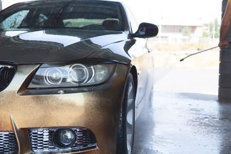 a man washes his car with waterの写真素材