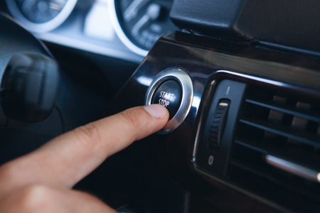 a man presses the start button in the carの写真素材