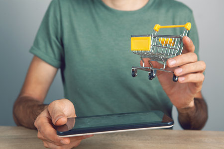 holding a tablet with a shopping basketの写真素材
