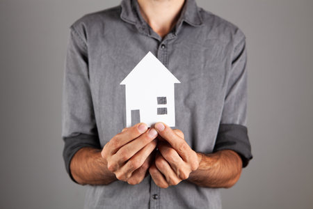 man holding house on gray backgroundの写真素材