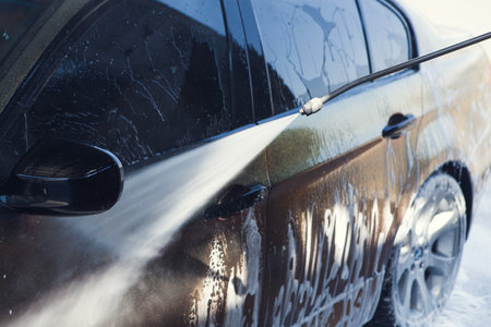 a man washes his car with waterの写真素材