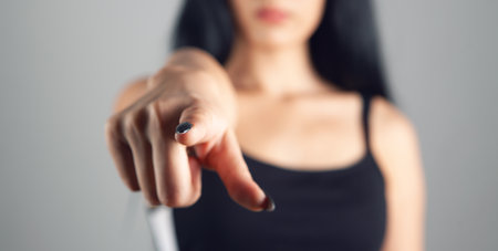 woman points finger on gray backgroundの写真素材