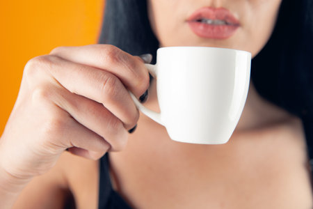young woman drinking coffee from a cupの写真素材