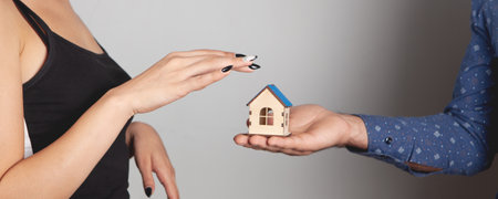 a man gives a wooden house to a womanの写真素材