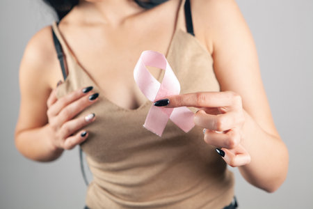 woman holding pink ribbon on gray backgroundの写真素材