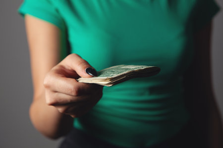 woman is counting money on gray backgroundの写真素材