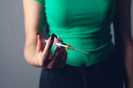 girl holding a syringe with drugsの写真素材