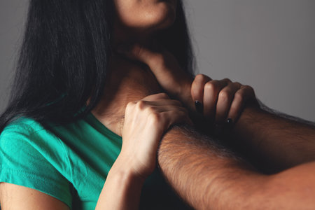 husband strangles wife on gray backgroundの写真素材