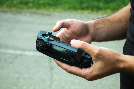 a man controls the drone's remote control during the day