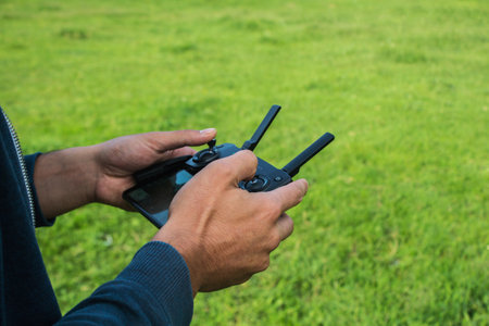 a man controls the drone's remote control during the day